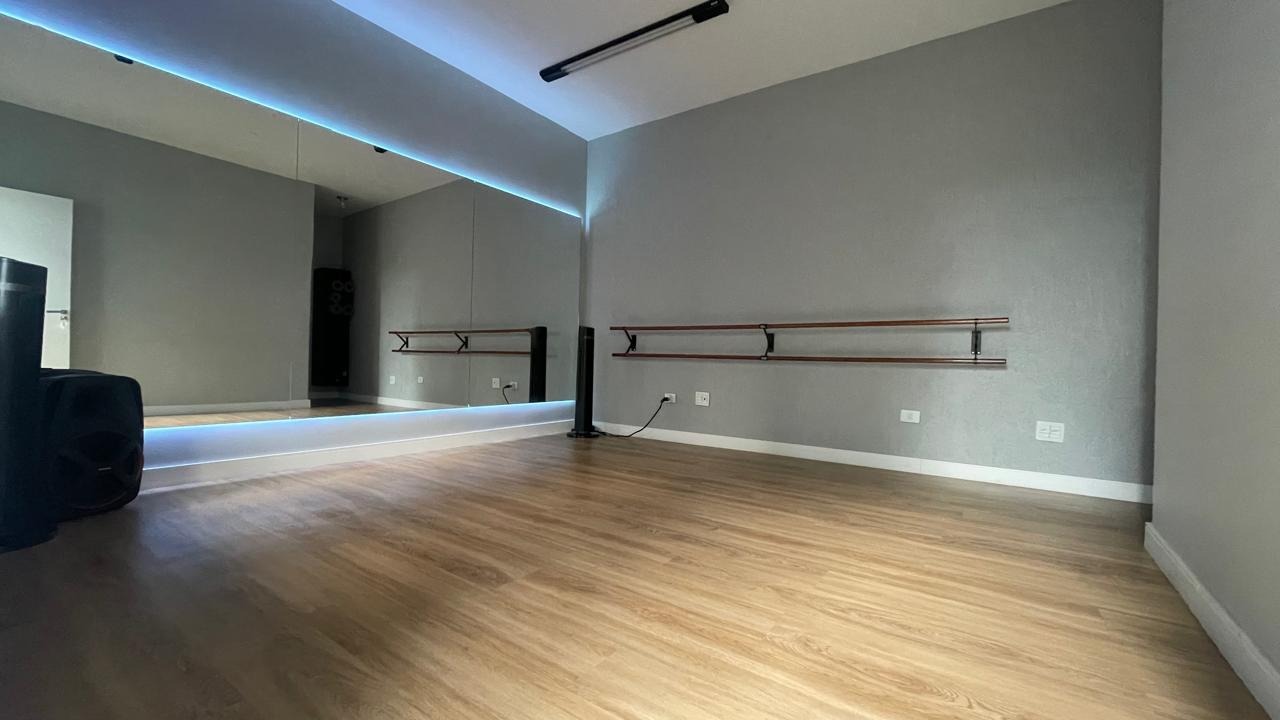 Sala 2 com piso de madeira, espelhos e iluminação LED azul no teto