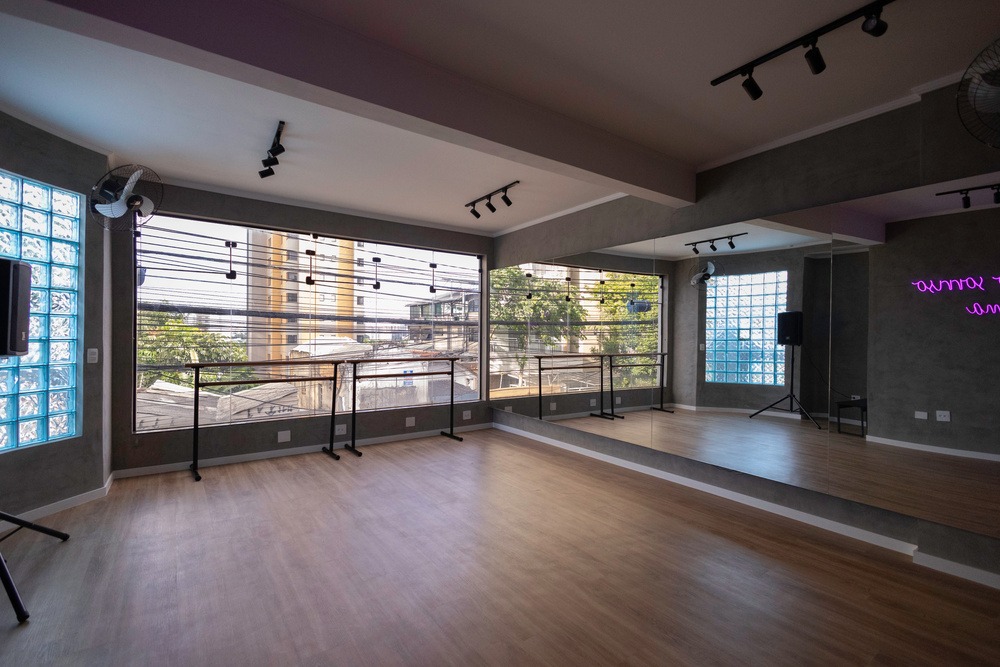 Sala 1 com barras móveis, piso de madeira e grande janela com luz natural